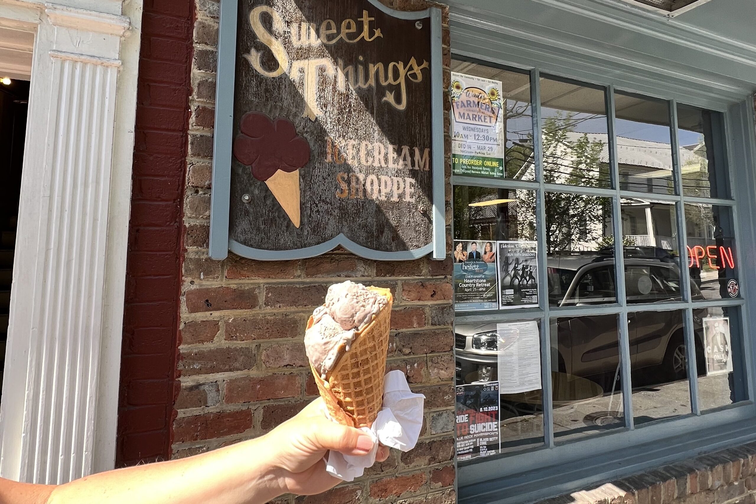 Person holding up ice cream cone in front of Sweet Things in Lexington, Virginia, United States