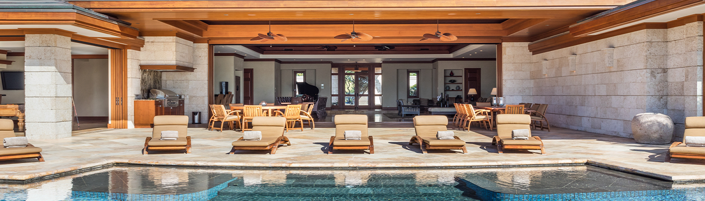 Lounge chairs by a pool at a rental property provided by Homes & Villas by Marriott Bonvoy